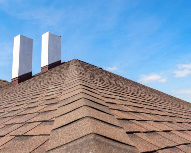 Orange/brown shingled roof with two white chimeny stacks