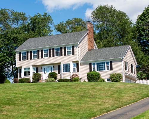 White siding house on a grassy hill
