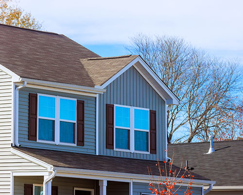 White siding house on a grassy hill